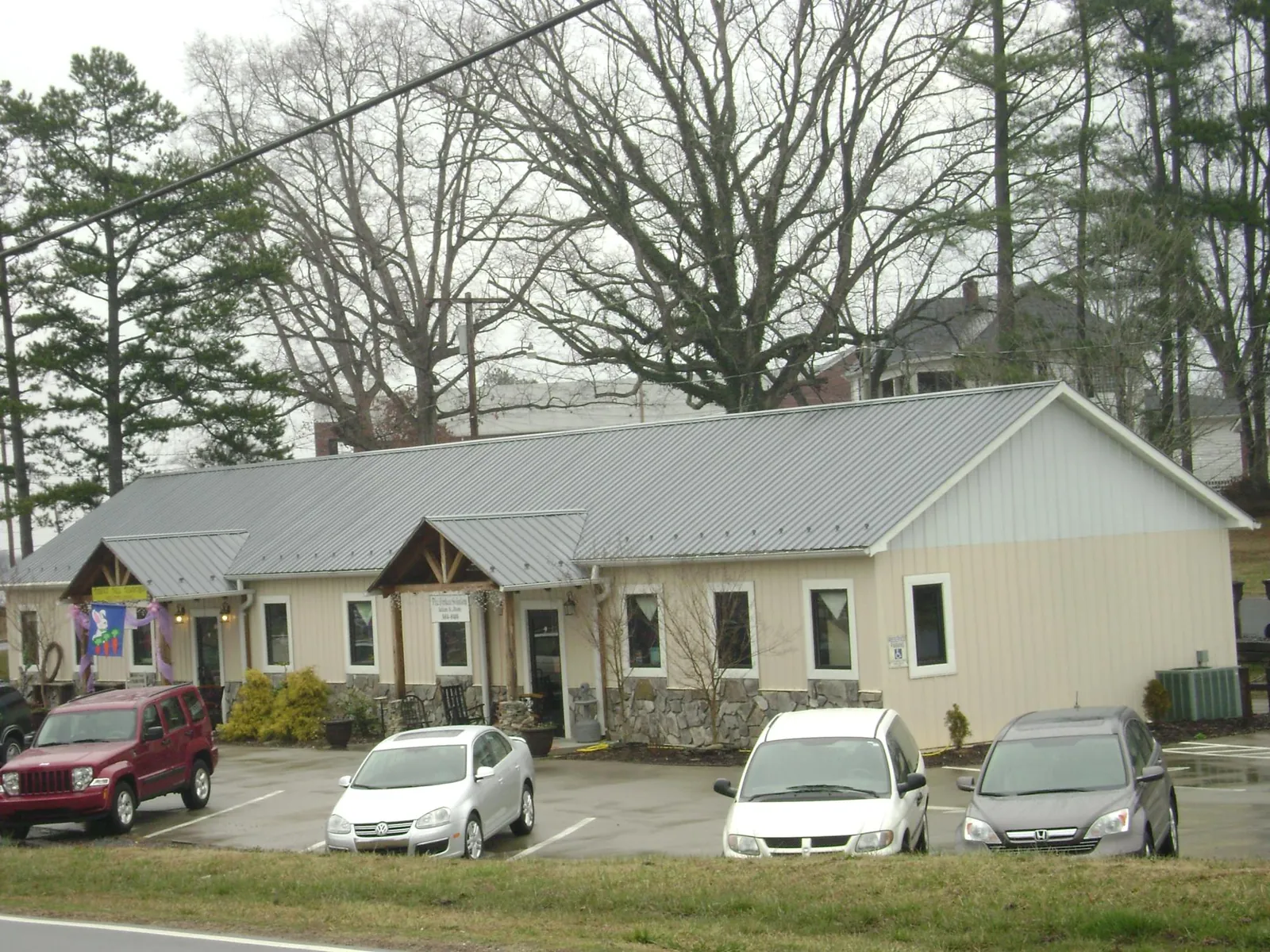 Gray metal roof with timber entry brackets on a small commercial building in Maysville